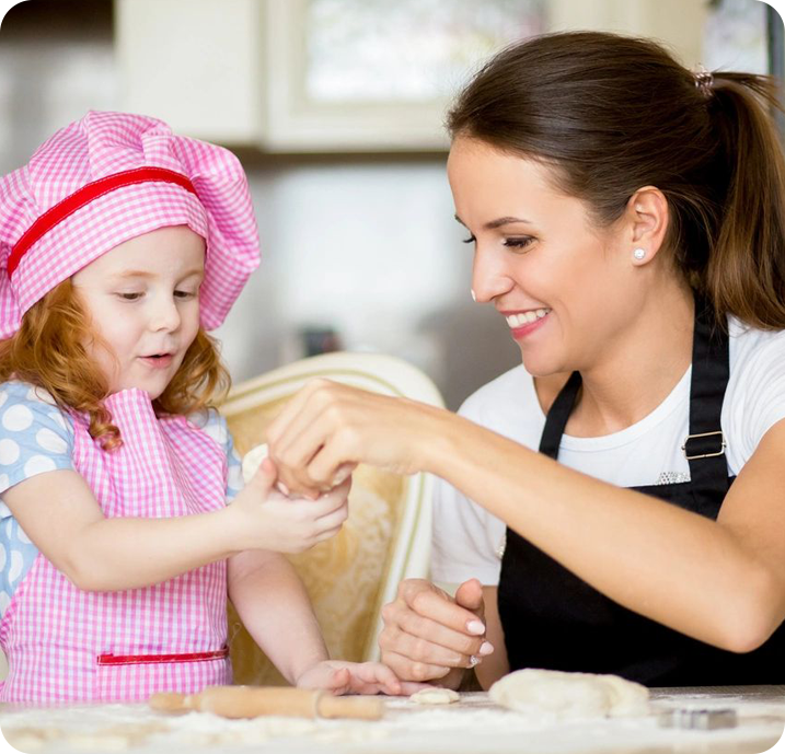 A woman and child are making cookies together.